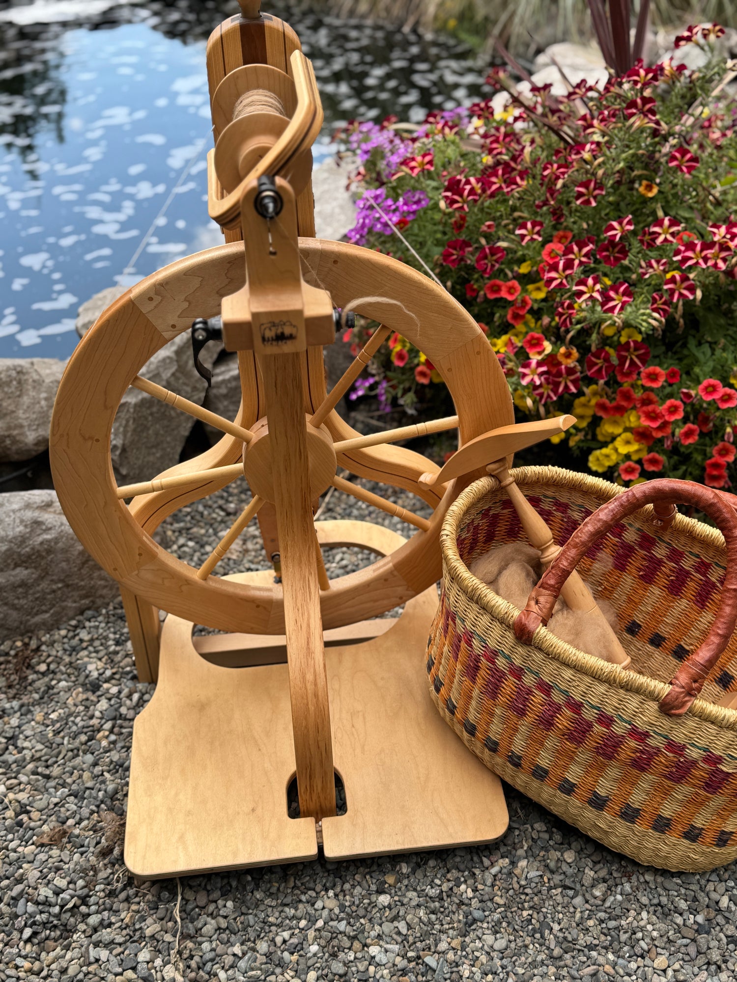 “Handspun yarn skeins on a spinning wheel in a summer garden – Gitti’s Yarn and Wool”